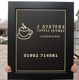 Black painted wooden frame wit a matt black panel and gold text.