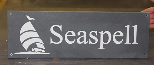 engraved corian house sign with white letters