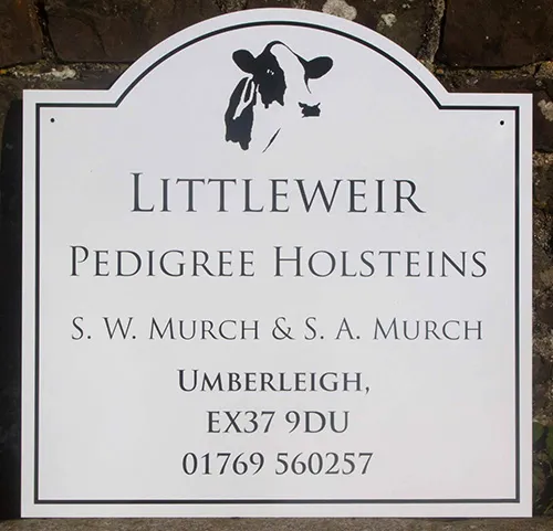 Shaped farm sign with cow image