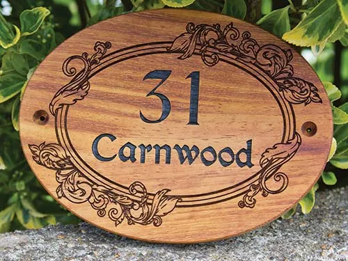 This sign includes a decorative border. Oval wooden house sign