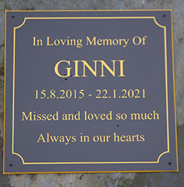 Acrylic memorial with black surface and engraved gold lettering.