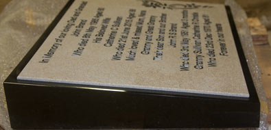 Engraved corian plaque on a black granite wedge.
