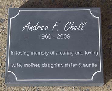 Slate memorial tablet with a line border with indented corners.