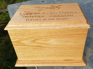 A simple tall oak ashes casket.