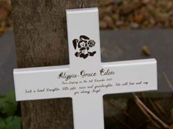 Wooden cross painted white and laser engraved.
