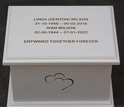 White ashes casket with engraved text.