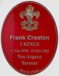 Red zinc plaque with raised letters and military crest.