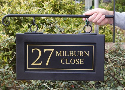 Oak framed hanging sign painted black with a wrought iron scroll bracket