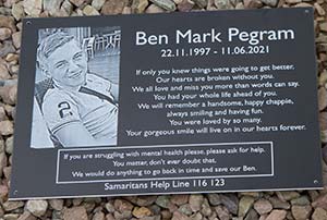 Black memorial plaque with photo.