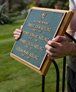 Bronze memorial on wrought iron plaque holder.