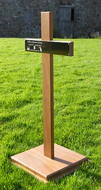 Oak cross on a wooden plinth with a black engraved plaque.