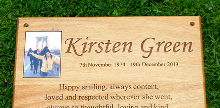 Photo plaque recessed into a wooden memorial.