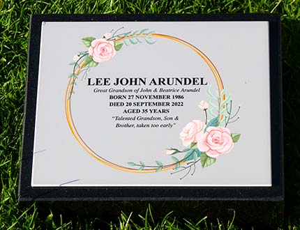 Full colour memorial on a black granite wedge.