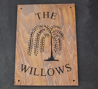 Sandstone sign with willow tree image.