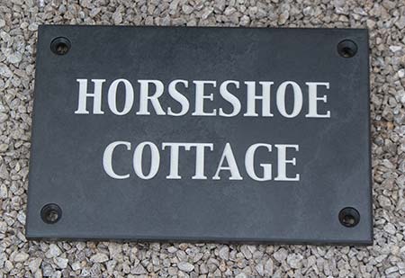 Slate house sign with countersunk holes drilled.