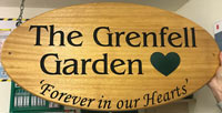 Wooden oval sign for The Grenfell Garden