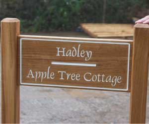 Wooden entrance sign morticed into two oak posts. Font - Dauphin