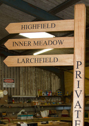 Wooden finger post with text on posts and arms