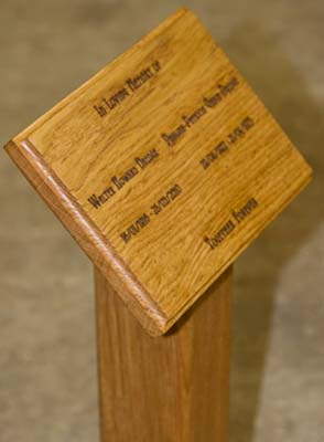Wooden memorial plaque fixed to post with wooden dowels